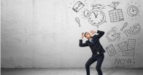 Man wearing black suit shielding face from drawings of alarm clocks, deadlines, and task lists.