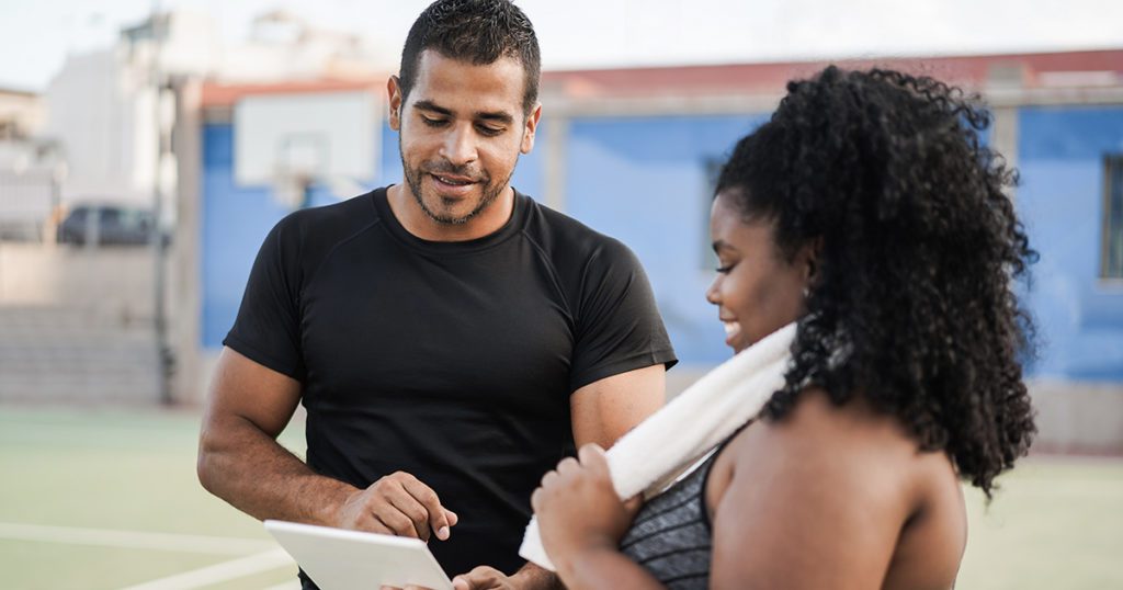 A nutrition and health coach reviews programs and goals with a client.